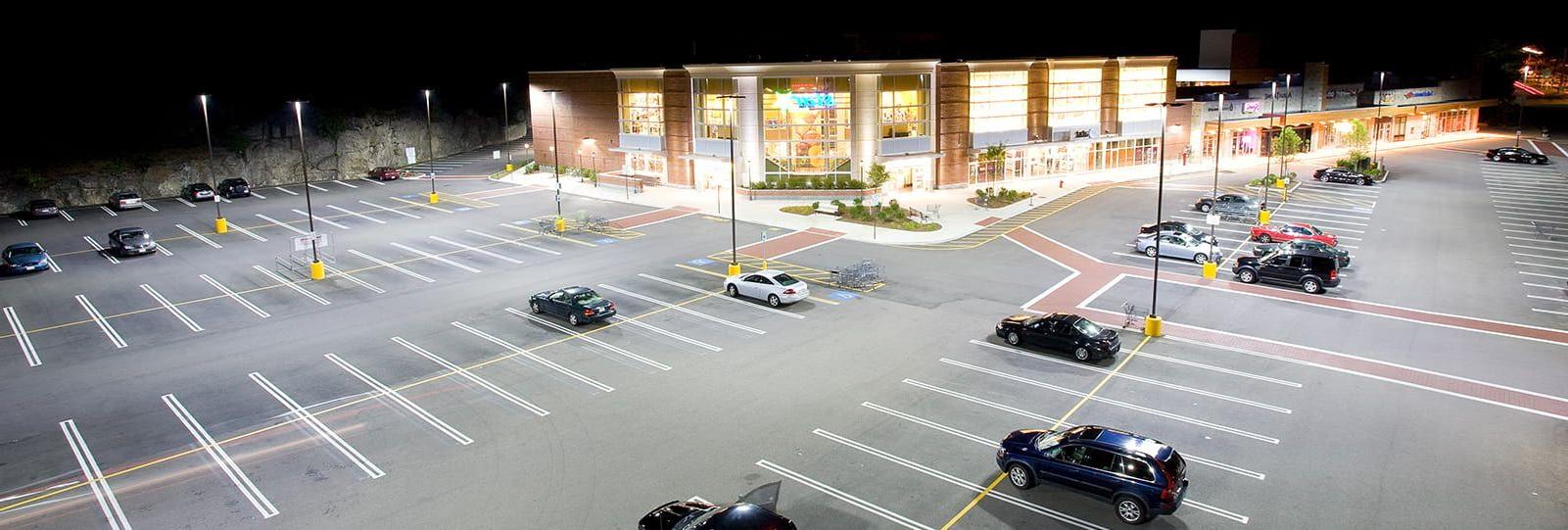 Retail store parking lot that is well lit with storefront lighting fixtures